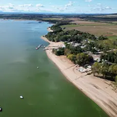 Widok z lotu ptaka na Zalew Mietkowski z piaszczystą plażą, mariną z łodziami i zielonymi terenami rekreacyjnymi.